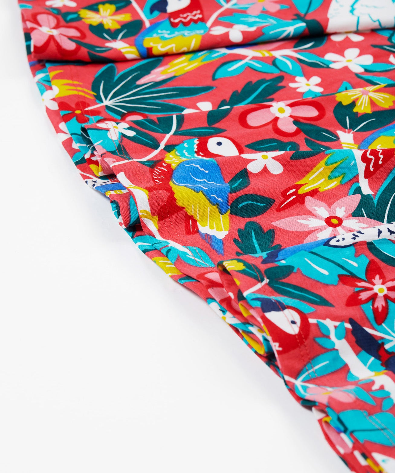 A close up of the bottom of Frugi Morwenna Skater Dress in the Birds Of Paradise print.