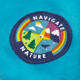 Close up of the navigate nature circular badge on the chest of the Frugi mullion long sleeve organic cotton rugby top.