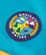 Close up of the navigate nature circular badge on the chest of the Frugi mullion long sleeve organic cotton rugby top.