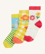 Frugi kids spring 3 pack socks - GOTS organic kids socks which features a white sock with a pink trim and flowers. A yellow gingham sock with a flower design and a green striped sock with a rabbit design.