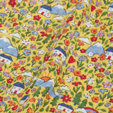 Close up of the highland houses themed print on the Frugi Natasha long sleeve organic cotton top in yellow. The print features flowers, mountains and a simple white house.