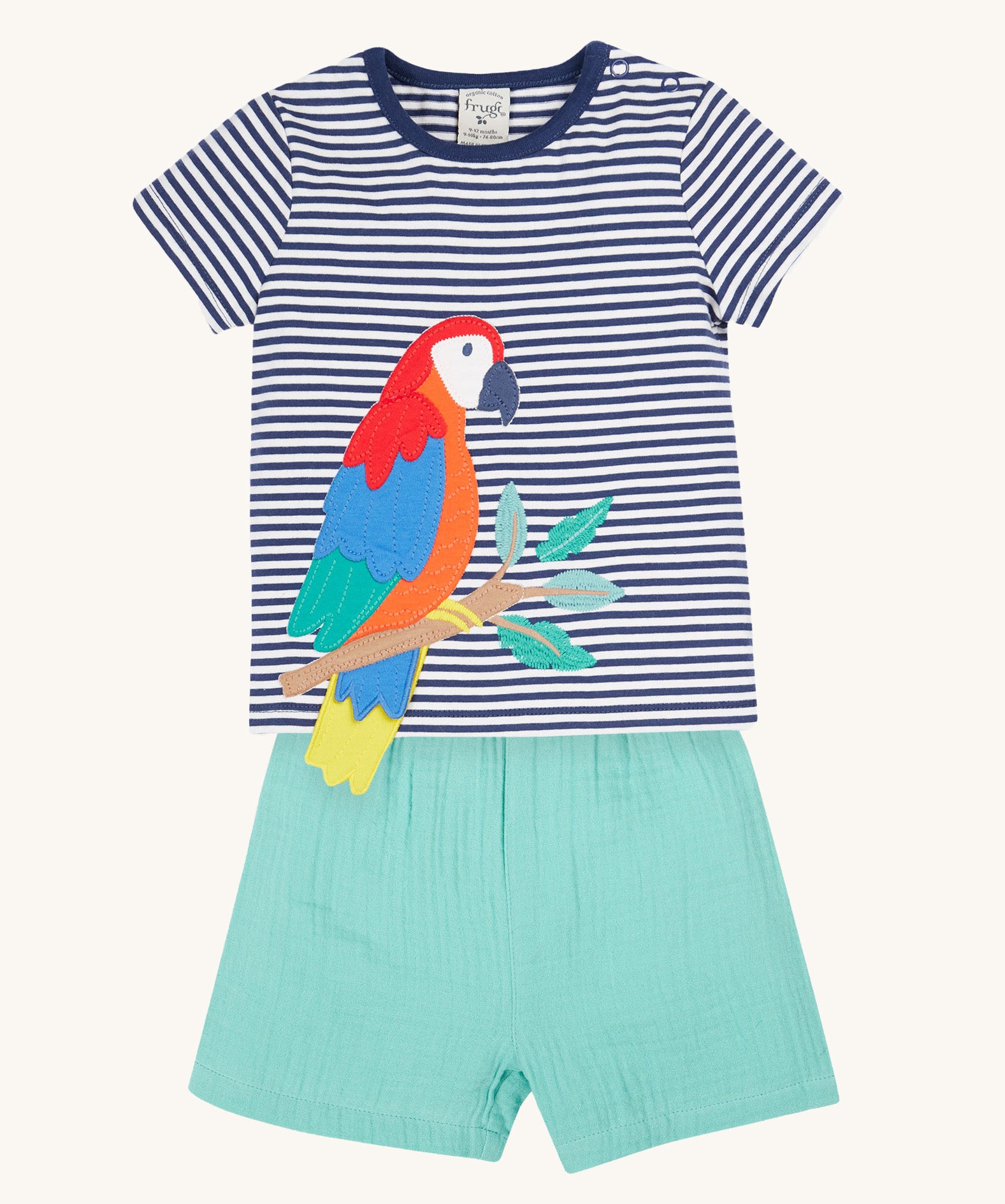 Frugi Marco Outfit laid flat, which includes a Navy Blue Stripe t-shirt with an embroidered Parrot, and shorts in the colour Moss.