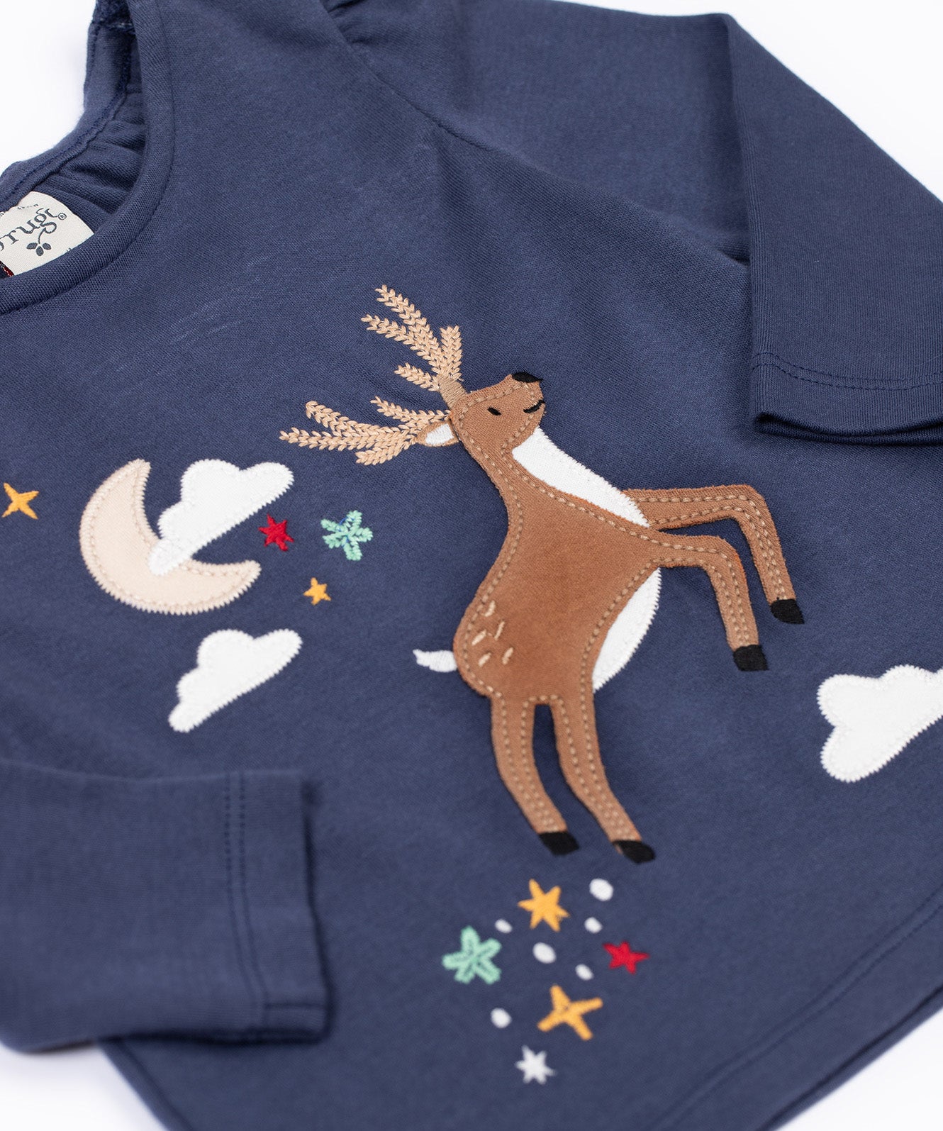 A close up of the front of the Frugi Navy Organic Cotton Caris Reindeer Applique Top. This top is a part of a wide range of organic cotton clothing for children available here at Babipur. 