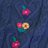 Close up of the embroidered pink and yellow flowers on the front of the Frugi organic cotton connie knitted waistcoat.
