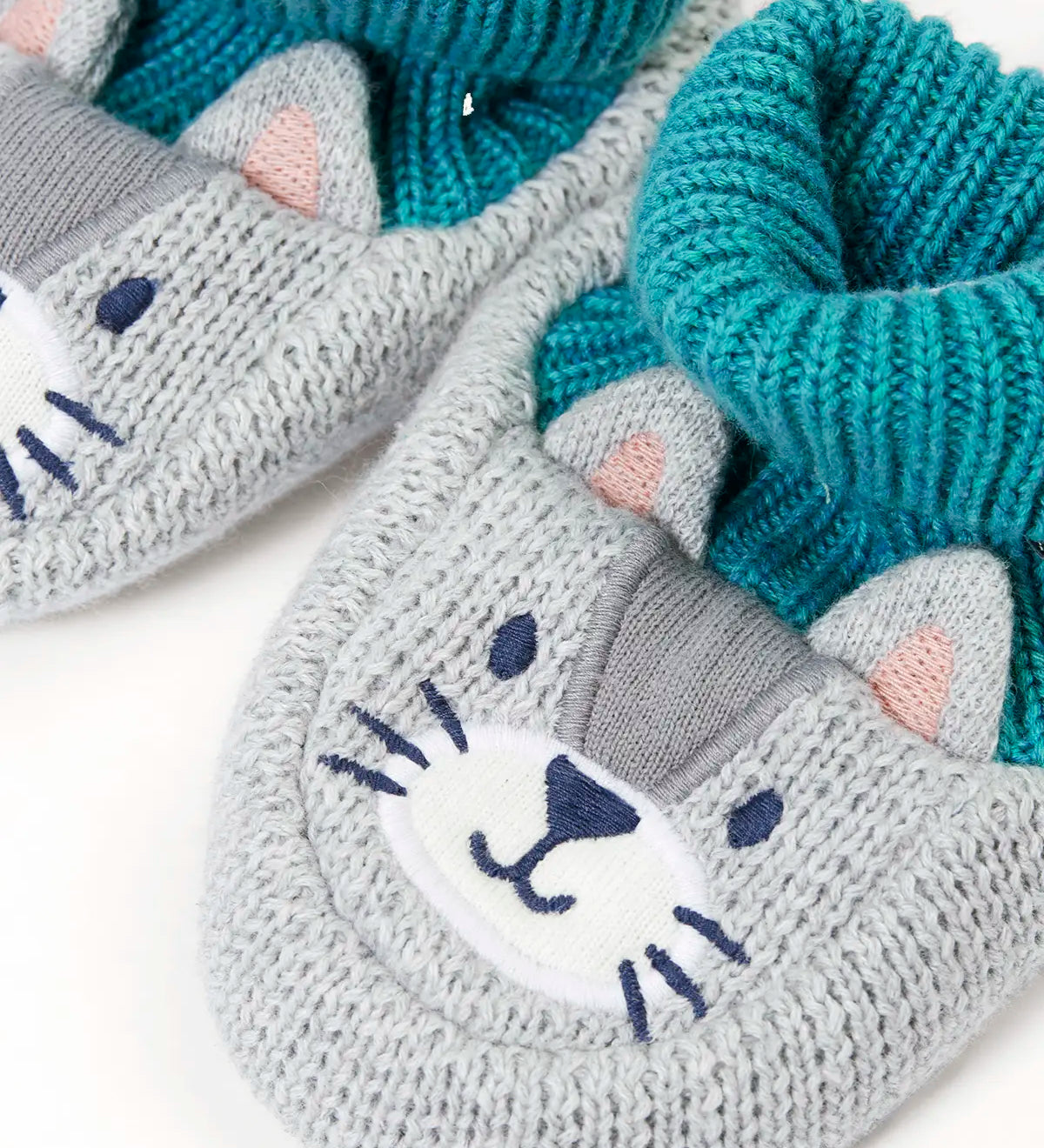Close up of the Frugi Noa organic cotton knitted baby booties in a grey wild cat design with turquoise lining.
