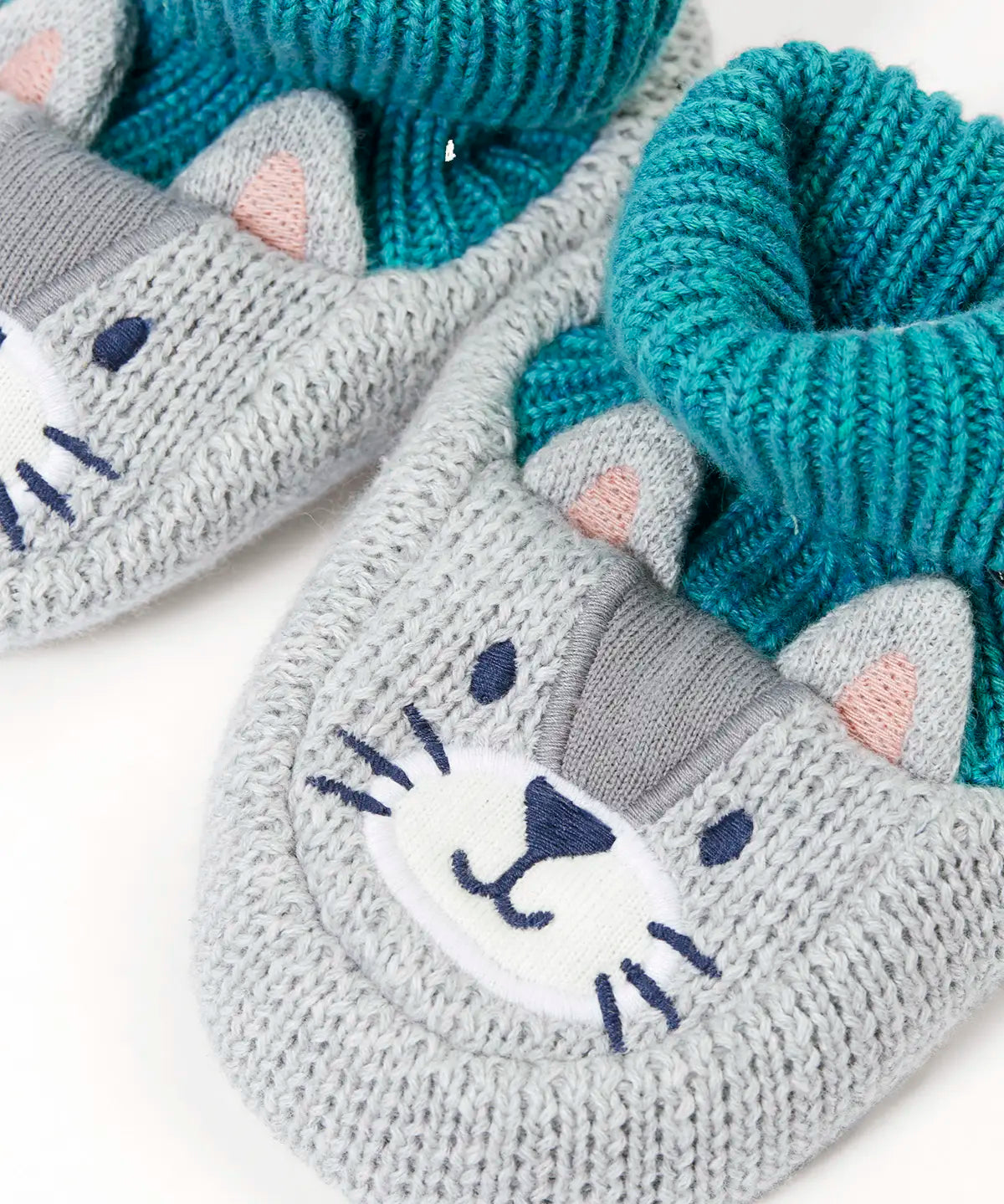 Close up of the Frugi Noa organic cotton knitted baby booties in a grey wild cat design with turquoise lining.