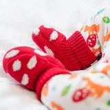 A close up of a baby wearing the Frugi kids noa knitted booties in red mushroom showing the knit detail. 