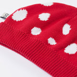 A close up of the Frugi kids noa knitted hat in red mushroom showing the ribbed brim detail on red organic cotton fabric