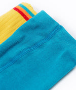 A close up of the waistbands on the Frugi Norah 2 pack tights, the mushroom design tights have a plain turquoise blue coloured waistband and teh bumblee yellow tights have a multi-coloured striped waistband.
