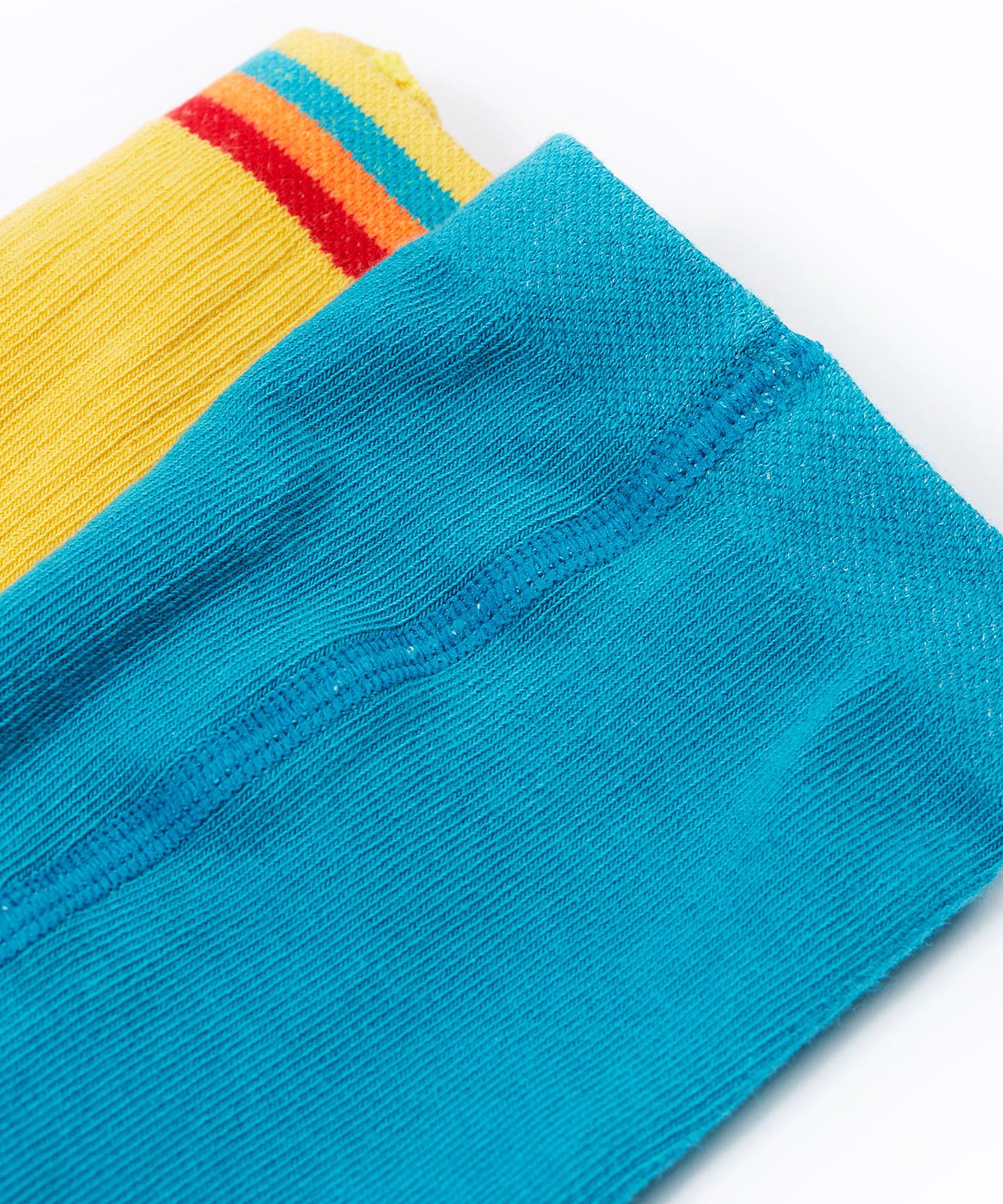 A close up of the waistbands on the Frugi Norah 2 pack tights, the mushroom design tights have a plain turquoise blue coloured waistband and teh bumblee yellow tights have a multi-coloured striped waistband.