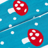 A close up of the knees on the mushroom design tights from the Frugi Norah 2 pack children's footed tights. The tights are turquoise blue with white spots all over the legs and the knees have a red mushroom on them.