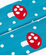 A close up of the knees on the mushroom design tights from the Frugi Norah 2 pack children's footed tights. The tights are turquoise blue with white spots all over the legs and the knees have a red mushroom on them.