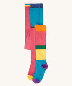 A 2 pack of Frugi Norah organic cotton footed kids tights. One pair has a multi-colour hotchpotch colour block design the other has a solid rose pink colour with multi-coloured waistband. 