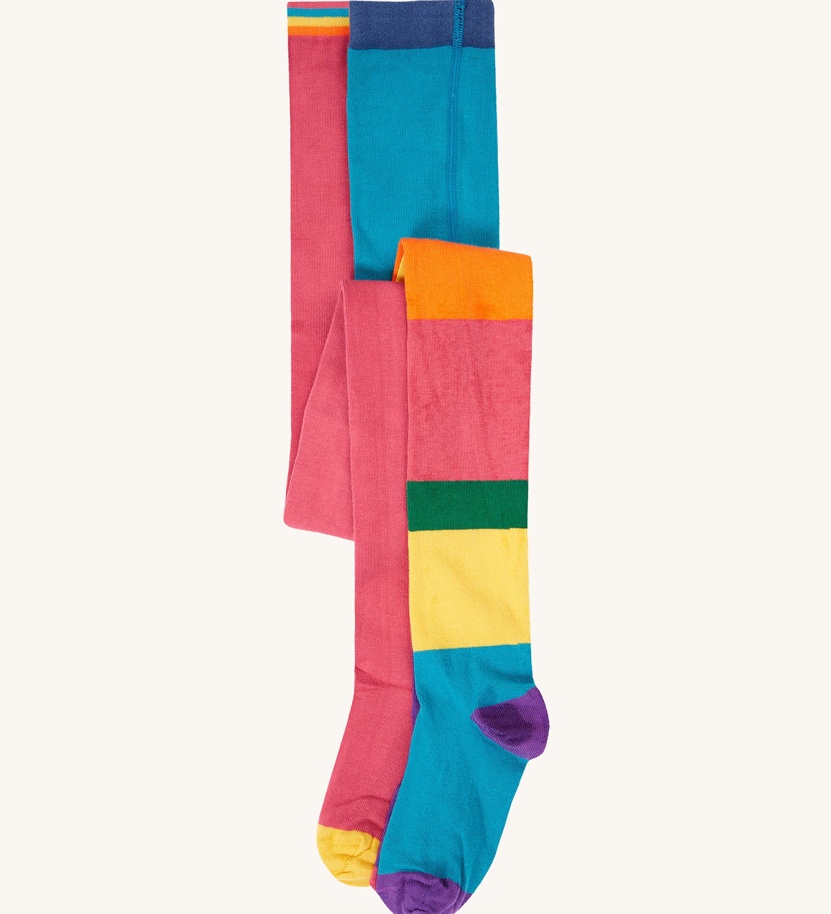 A 2 pack of Frugi Norah organic cotton footed kids tights. One pair has a multi-colour hotchpotch colour block design the other has a solid rose pink colour with multi-coloured waistband. 