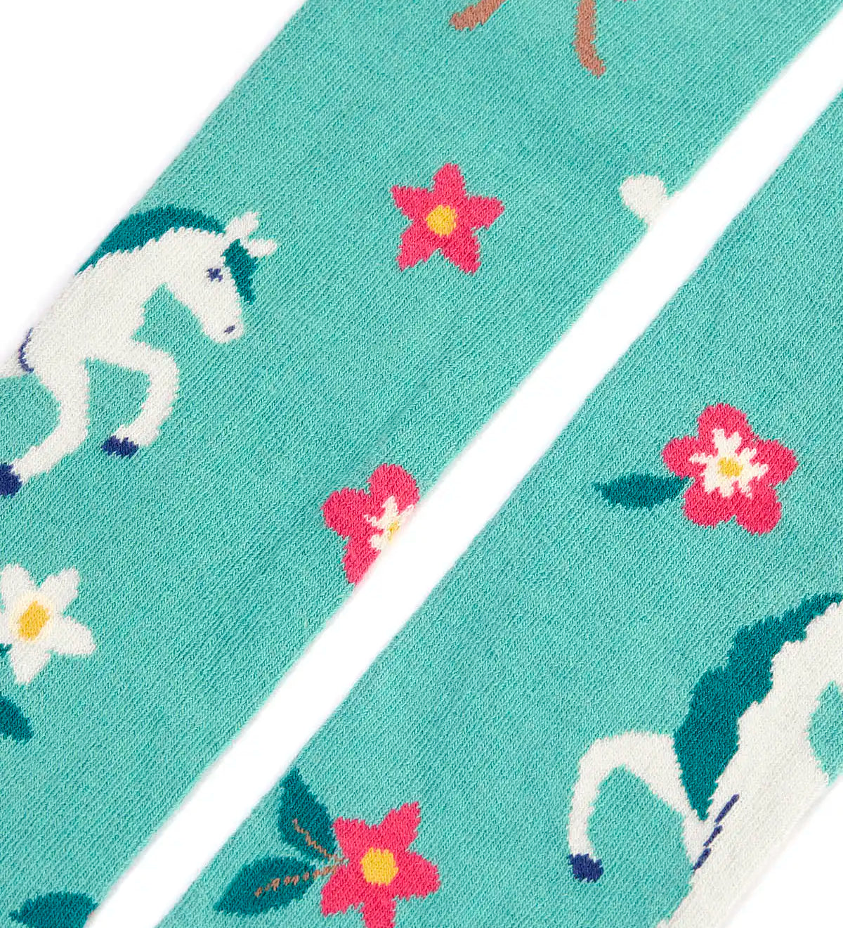 Close up of the Frugi children's Norah organic cotton knitted tights in moss green with unicorns.