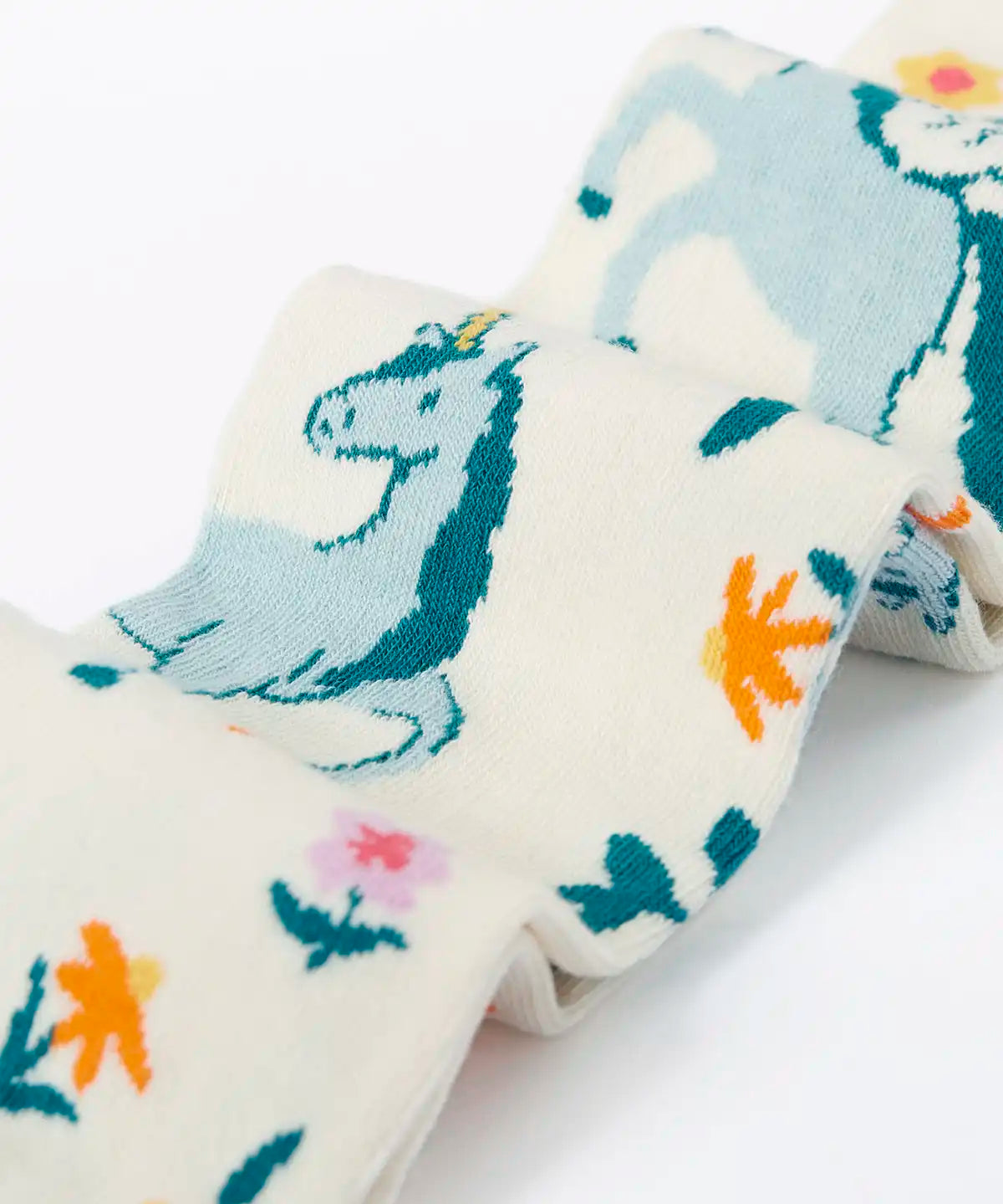 Frugi children's Norah organic cotton knitted tights in white with pegasus and flowers patterns.