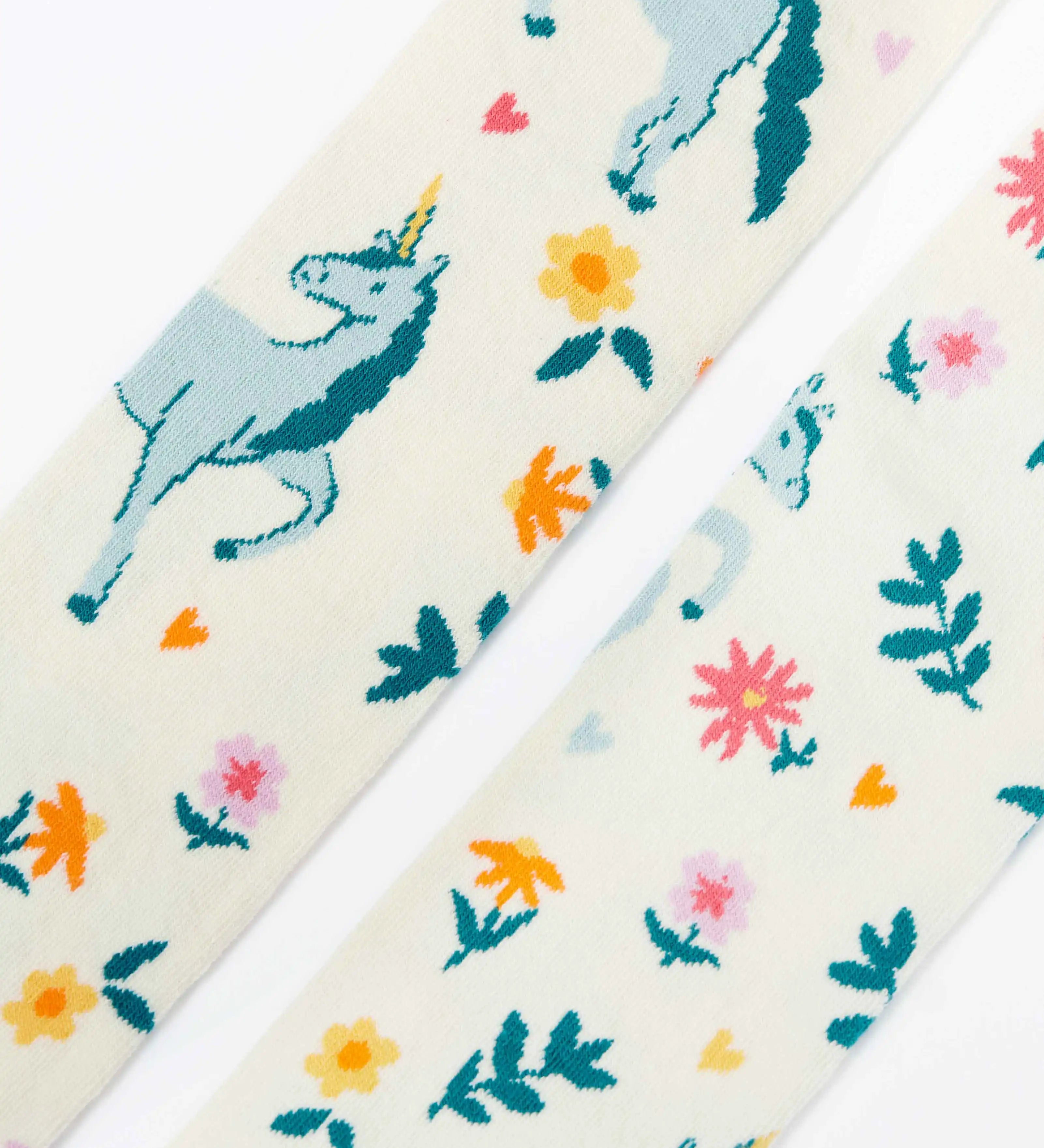 Frugi children's Norah organic cotton knitted tights in white with pegasus and flowers patterns.
