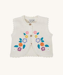 Frugi Oatmeal Flowers Connie Cotton Knitted Sleeveless Cardigan. This white oatmeal sleeveless cardigan has cute scalloped edges and is decorated with pretty embroidered flowers and leaves on the front. 
