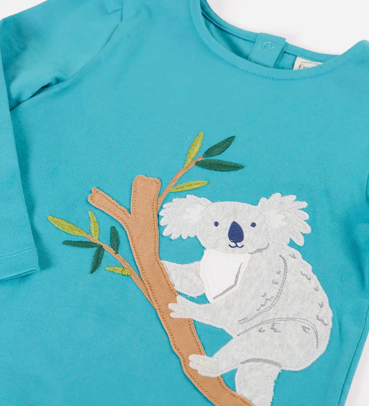 Frugi Ola outfit showing a close up a koala applique on the light blue organic cotton top and poppers on the back for easy dressing