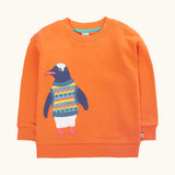 Frugi organic cotton superb sweatshirt salamander orange with penguin applique. The penguin is wearing a fairisle style tank top. 