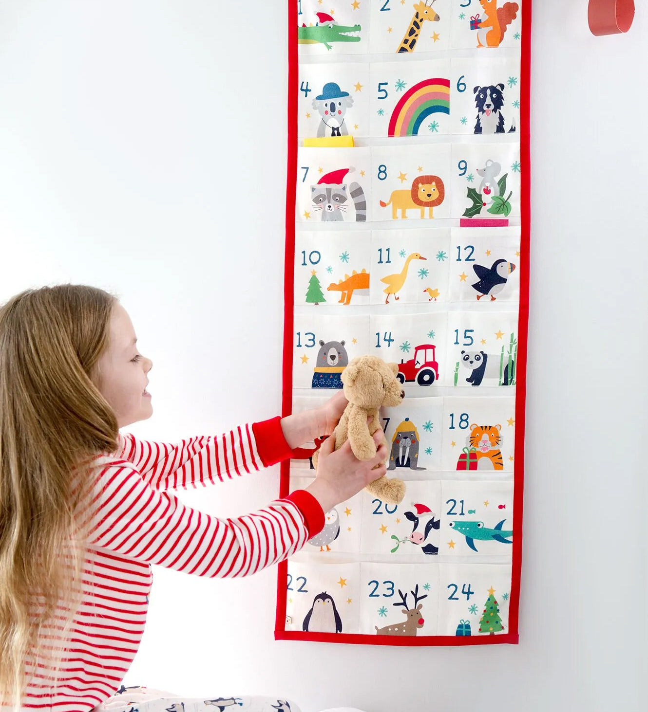 A little girl looking at her Frugi Organic cotton Christmas advent calendar, full of iconic Frugi Characters