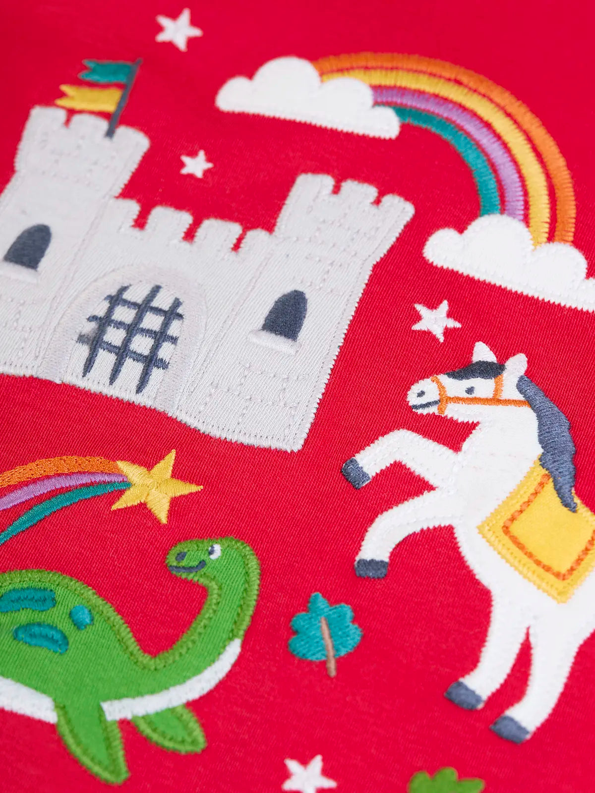 Close up of the appliques on the Frugi red organic cotton adventure magic applique long sleeve top. 