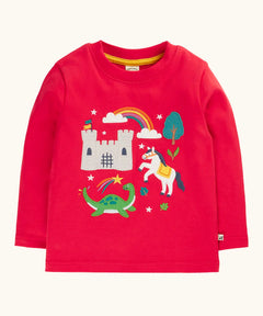 Frugi red organic cotton adventure magic applique top. Long sleeved top with castle, rainbow, tree horse and nessie appliques on the front. 
