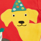 Close up of the yellow Labrador dog wearing a green party hat applique on the Frugi organic cotton adventure circular long sleeve top .