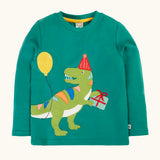 Frugi organic cotton adventure long sleeve hut green child's top with t-rex dinosaur wearing a party hat carrying a present with a yellow balloon appliques on the front.