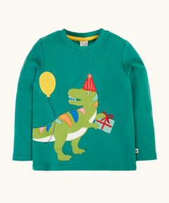Frugi organic cotton adventure long sleeve hut green child's top with t-rex dinosaur wearing a party hat carrying a present with a yellow balloon appliques on the front.