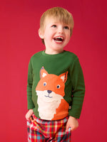 Child wearing the Frugi organic cotton adventure long sleeve top in forest green with large fox applique on the front with festive check trousers.