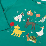 Close up of the Frugi organic cotton anna pet Paw-Ty appliqué long sleeve children's top. Green top with applique dogs, guinea pig, budgie, goose and tortoise wearing party hats and balloons and star sparkle details. 