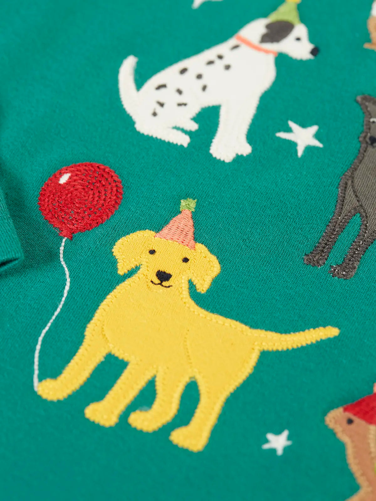 Close up of the yellow labrador applique with embrodered party hatand  balloon detail on the Frugi organic cotton anna pet Paw-Ty long sleeve children's top. 