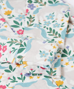 A close up of the fold over cuffs on the babygrow included in the Frugi Unicorn Forest Organic Cotton Babygrow Gift Set. This baby grow set  comes with a white babygrow decorated with an all over unicorn forest themed print and comes with a matching bandanna style bib. 
This baby gift set is a part of a wide range of organic cotton clothing for children available here at Babipur. 
