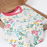 A close up of the bandanna style bib included in the Frugi Unicorn Forest Organic Cotton Babygrow Gift Set. This baby grow set  comes with a white babygrow decorated with an all over unicorn forest themed print and comes with a matching bandanna style bib. 
This baby gift set is a part of a wide range of organic cotton clothing for children available here at Babipur. 