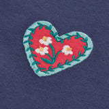 Close up of a heart applique featured on the Frugi bethany organic cotton long sleeved child's navy top with floral embroidery details.