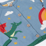 A close up of the front of the Frugi Organic Cotton Reva Dragon Skies Knitted Kids' Cardigan. This blue cardigan features a fun, colourful design featuring a green dragon, stars, rainbow, clouds and a mushroom. This cardigan is a part of a wide range of organic cotton clothing for children available here at Babipur. 