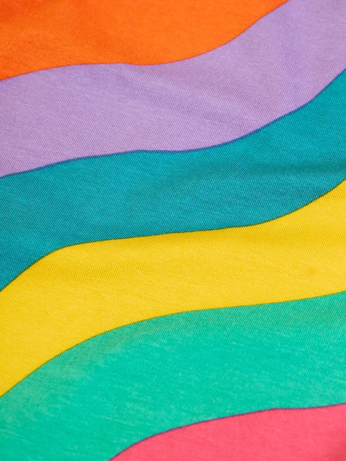 Close up of the rainbow ric rac tripes on the Frugi organic cotton bryher long sleeve top.