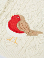 Close up of a robin applique on the Frugi organic cotton natural cream cable knit baby cardigan.