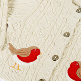 Close up of the Frugi organic cotton natural cream cable knit baby cardigan with robin appliques.