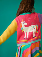 Back of a child wearing the Frugi organic cotton cammie cardigan showing the large unicorn on the back with a rainbow dress underneath.