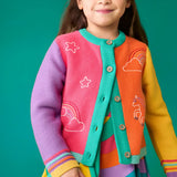 Child wearing the Frugi organic cotton cammie cardigan with a hotchpotch unicorn design. white star, clouds and unicorn outlines details on the front. 