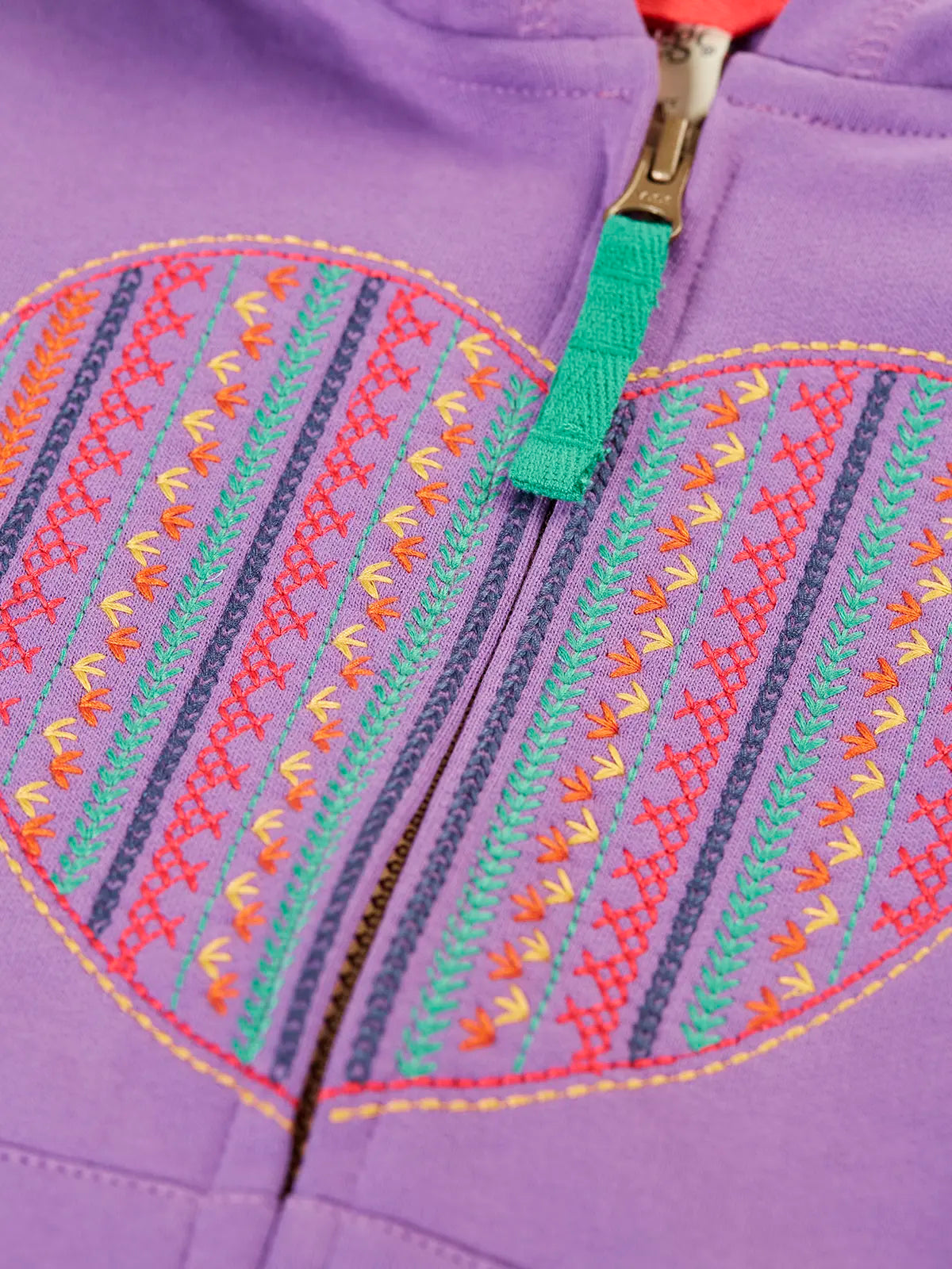 Close up of the multicoloured embroidered heart design on the front of the Frugi organic cotton purple periwinkle carbis zipped children's hoodie. 
