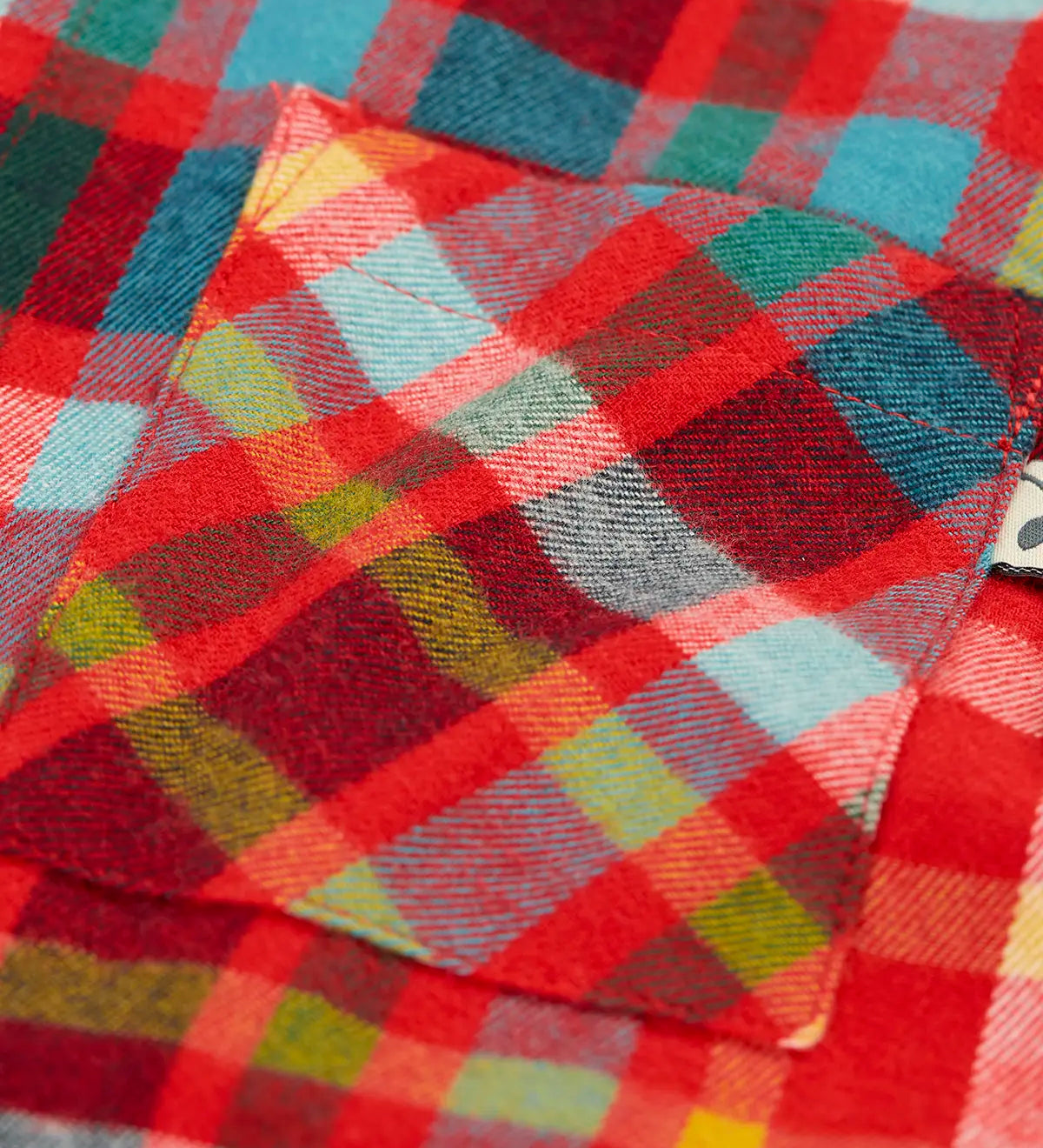 Close up of the chest pocket on the Frugi organic cotton festive check hector long sleeve shirt.