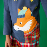Close up of the fox applique on the long sleeved top from the Frugi organic cotton caden check festive fox pyjamas. The fox is wearing a blue bobble hat and a check shirt.