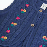 Close up of the the front of the Frugi organic cotton connie knitted waistcoat  showing the scalloped edges.