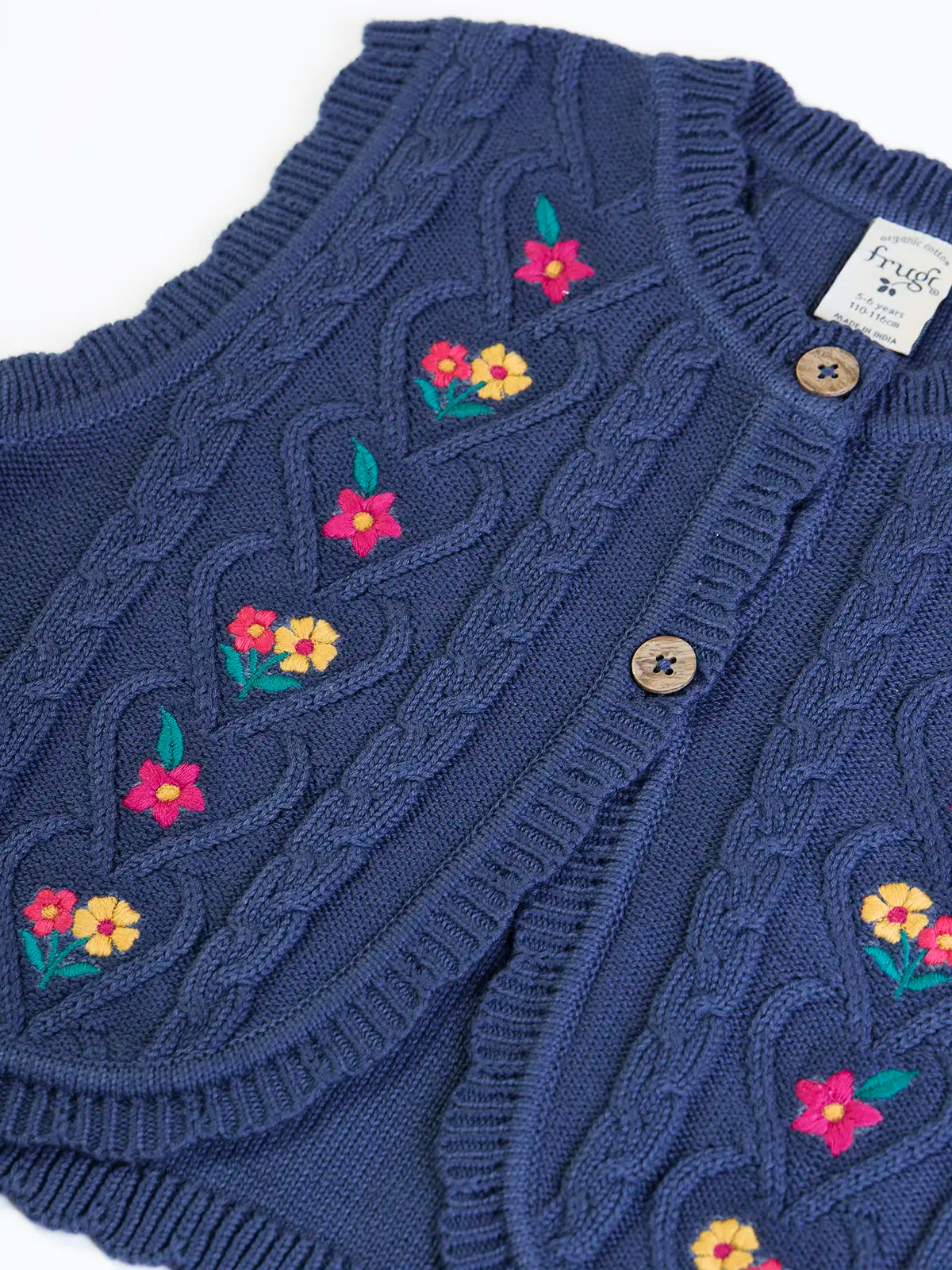 Close up of the the front of the Frugi organic cotton connie knitted waistcoat  showing the scalloped edges.