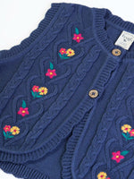 Close up of the the front of the Frugi organic cotton connie knitted waistcoat  showing the scalloped edges.
