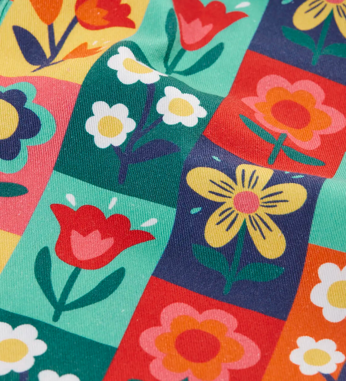 Close up of the rectangle flower stamps on the Frugi organic cotton ethel flared dungarees.