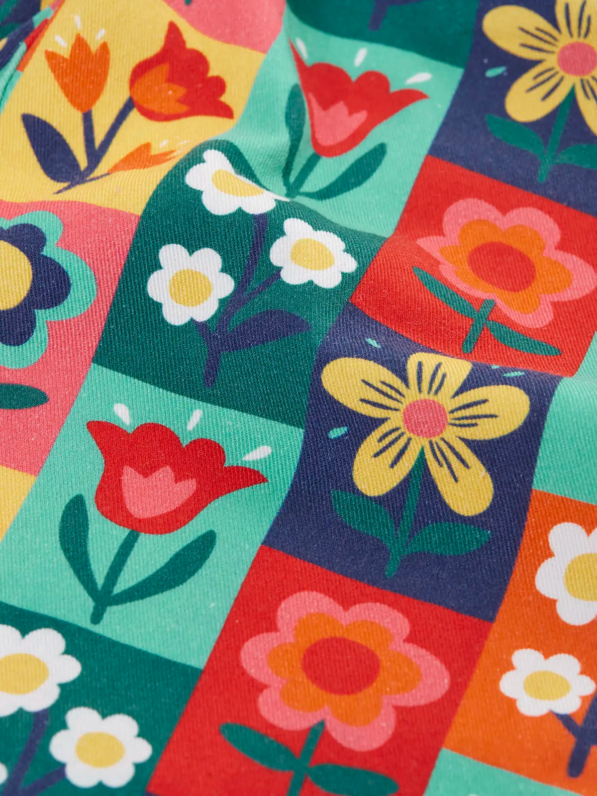 Close up of the rectangle flower stamps on the Frugi organic cotton ethel flared dungarees.